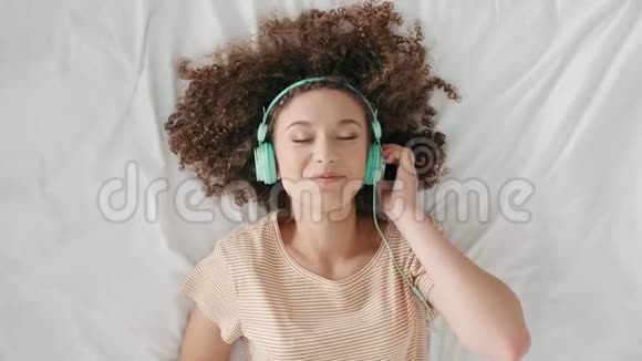 躺在床上听音乐的年轻女子视频的预览图