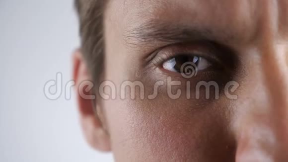 闭上年轻白种人的棕色眼睛在白色背景下看镜头视频的预览图