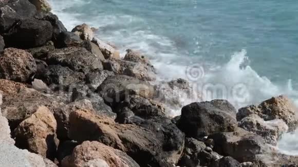 近距离观看大海浪的石头波浪冲击岩石海岸蔚蓝的海水撞击在岩石海岸上泼水视频的预览图