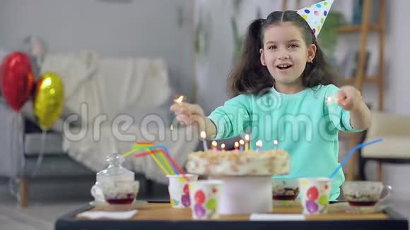 小女孩在蛋糕的背景下挥舞着火花视频的预览图