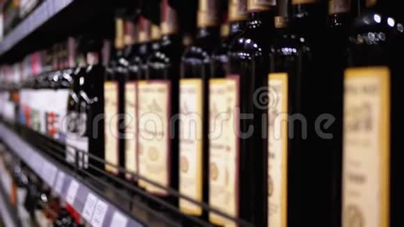 布卢尔商店橱窗上装有价格标签的瓶装葡萄酒的架子和架子超市卖酒视频的预览图