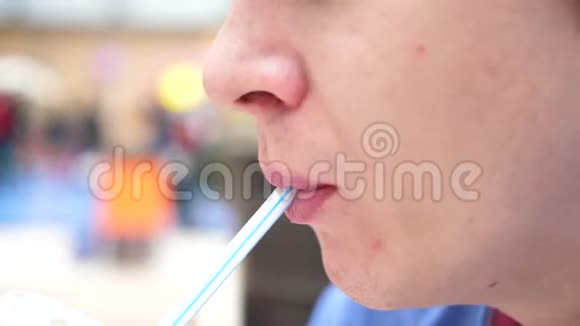 一个在快餐店里的人通过管子喝一种碳酸的甜饮料嘴巴紧闭视频的预览图