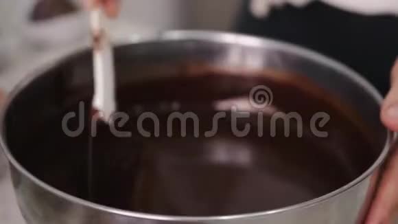 家庭主妇用铲子搅拌融化的巧克力视频的预览图