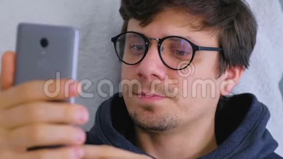 快乐的年轻人戴眼镜在智能手机上说视频聊天在线约会视频的预览图