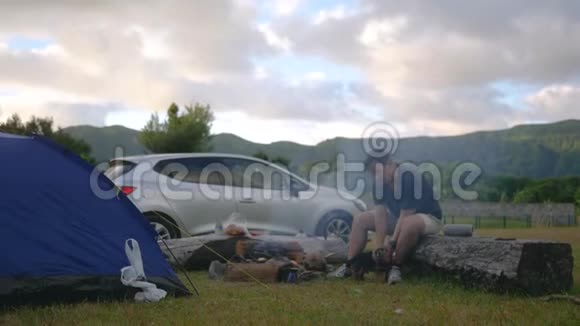 在大自然中露营在风景和汽车的背景下与一只狗玩耍视频的预览图