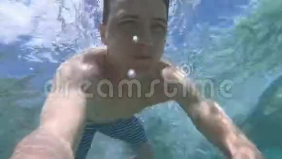 年轻人在蓝色干净的水里潜水视频的预览图