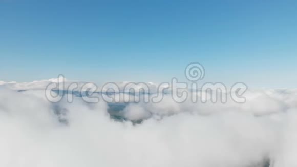 鸟瞰全景白天飞行在阳光明媚的一天飞越云层和山上的概念视频的预览图