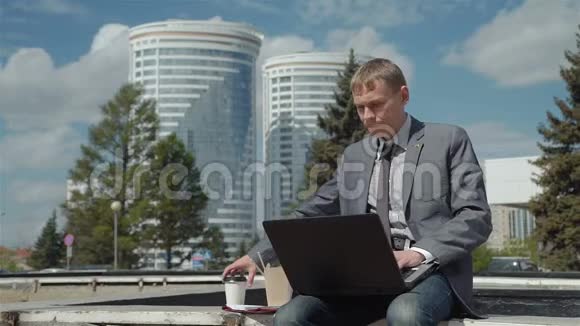 商人一边喝咖啡一边用笔记本电脑视频的预览图