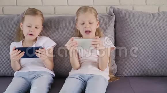双胞胎在沙发上用手机视频的预览图
