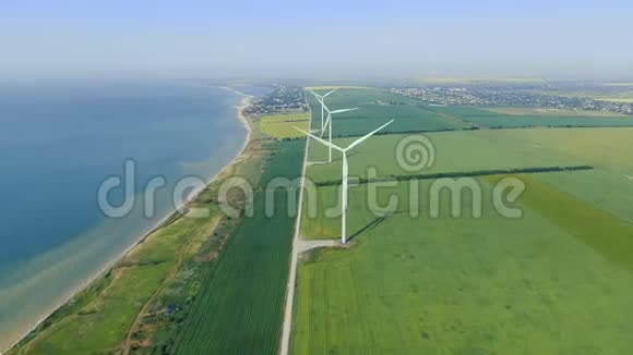 摄像机沿着海岸拍摄背景是风力涡轮机和城市视频的预览图