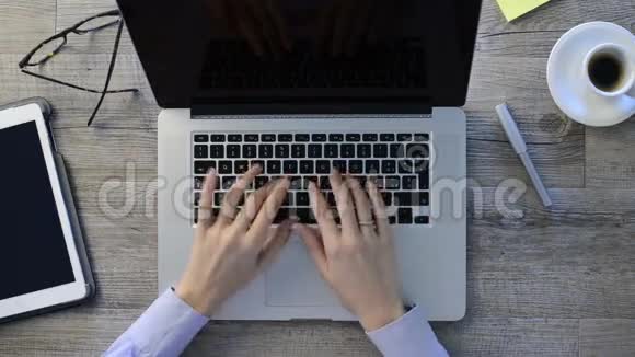 一个女人在她的笔记本电脑键盘上打字的特写镜头女孩在电脑办公室工作把注意力集中在键盘上视频的预览图