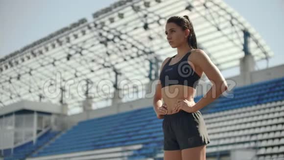美丽的女运动员在体育场呼吸和准备开始比赛种族激励和调整视频的预览图
