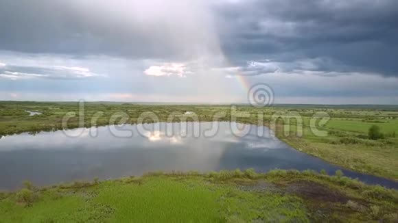 宁静的湖映着绿草和绿树之间的云视频的预览图