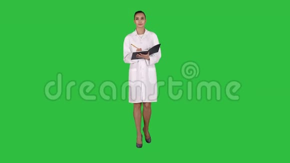 有创意的年轻女医生拿着笔记本走在绿色的屏幕上铬键视频的预览图