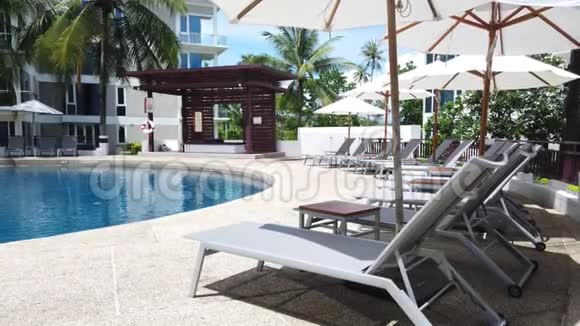 豪华酒店度假酒店室外游泳池周围的雨伞和椅子视频的预览图