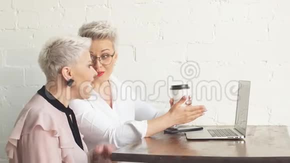 商务小姐的两个老朋友坐在咖啡馆里讨论一个商业想法视频的预览图