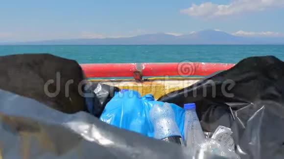 垃圾桶装满了带海的垃圾背景上有海洋登陆的海洋志愿者在海里收集垃圾回收视频的预览图