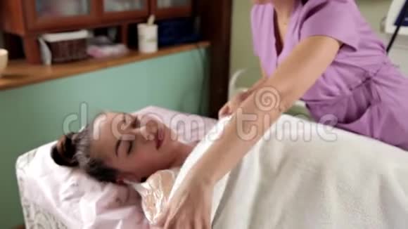 休息的一部分一位平静梦幻的女士躺在毛巾上身上戴着一个奶油面具水疗中心皮车视频的预览图