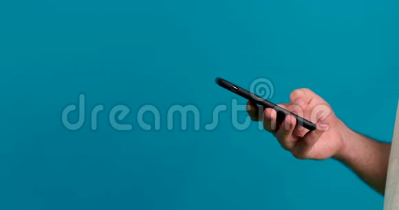 在蓝色背景上隔离的人使用智能手机的歪视角视频的预览图