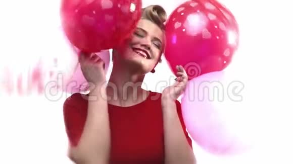 非常微笑和快乐的金发女人正在和她在情人节得到的气球跳舞视频的预览图