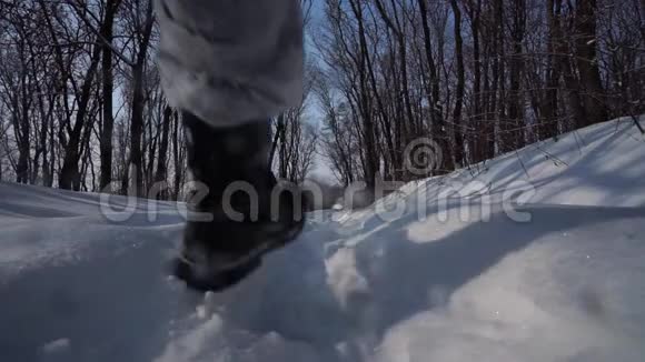 人在镜头前迈开脚步在天空中走在雪地里后景鞋迹特写底部视图视频的预览图