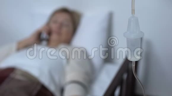 老年女性病人在病床上打电话突然感到剧烈头痛视频的预览图