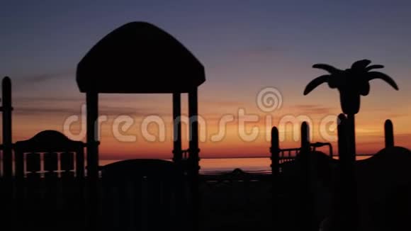 夏季日落时用棕榈树特写的游乐场视频的预览图