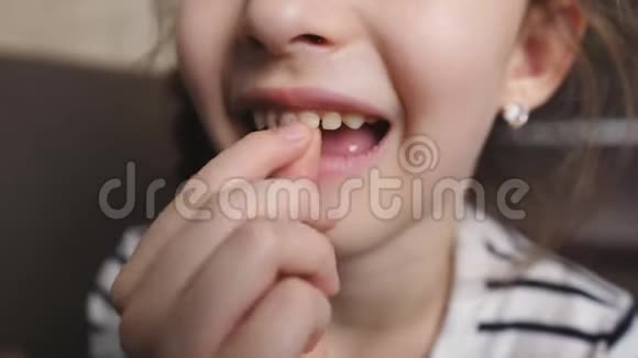 小女孩手松开嘴里的一颗牙视频的预览图