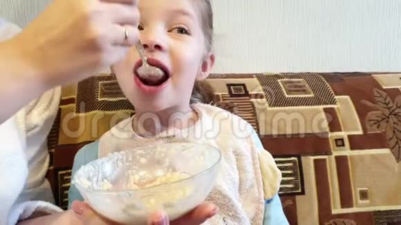 一个女人在厨房里给一个小女孩喂燕麦片视频的预览图