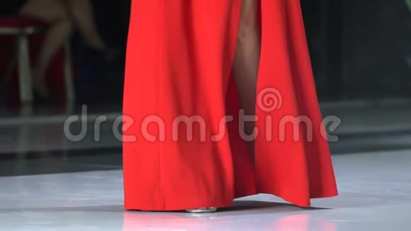 穿高跟鞋在舞台讲台上行走的性感美丽的女腿穿红色裙子的女女孩歌手视频的预览图