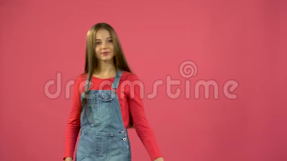 女孩从袋子里得到一只红色的鞋子很高兴粉色背景视频的预览图