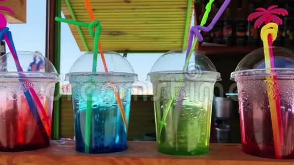 各种新鲜的异国鸡尾酒或果汁玻璃与稻草在海滩酒吧视频的预览图