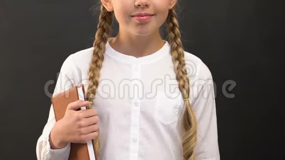 小女生拿着书和粉笔站在黑板上教育视频的预览图