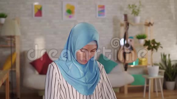 年轻的穆斯林妇女戴着头巾脸上有烧伤疤痕看着镜头视频的预览图