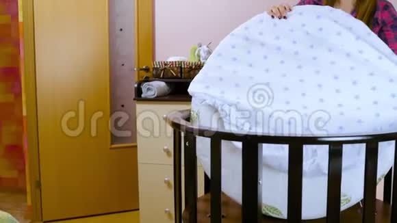 为新生儿做准备的妇女为会议做准备折叠儿童木制家具摇篮婴儿床视频的预览图