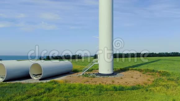 有风力涡轮机的大片绿野和附近的一些部件视频的预览图