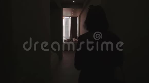 可爱时尚的黑发女孩来到她的新公寓穿过走廊来到窗户与一个美丽的美丽视频的预览图