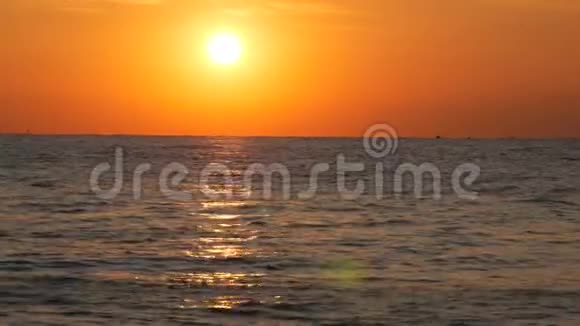 大海上的晚霞或黎明水面上巨大的圆形太阳在海中反射出模糊的阳光视频的预览图