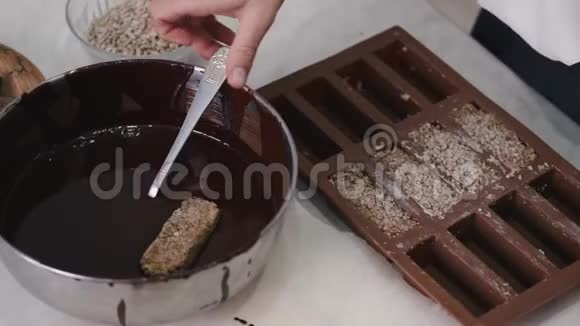 一个糖果师正在融化的巧克力里蘸一种甜味视频的预览图