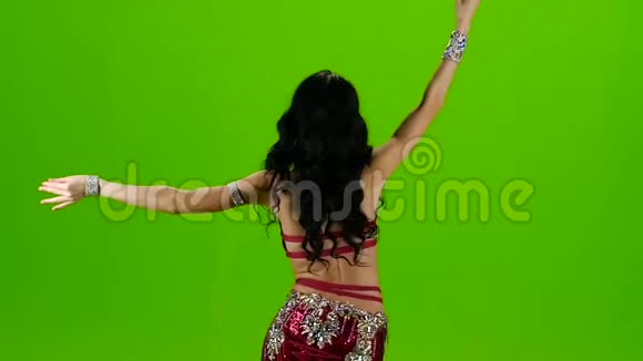 女人站在服装后面带着装饰品跳舞肚皮舞绿色屏幕慢动作视频的预览图