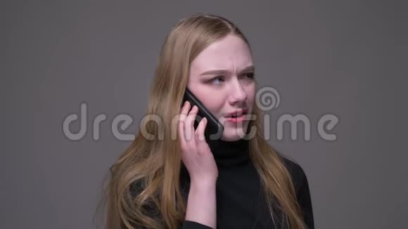 一位年轻漂亮的黑发女性的特写镜头她打电话时情绪激动背景与外界隔绝视频的预览图