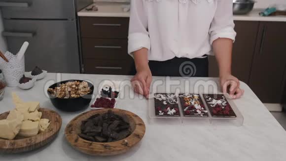 家庭主妇正在用浆果和核桃装饰巧克力视频的预览图