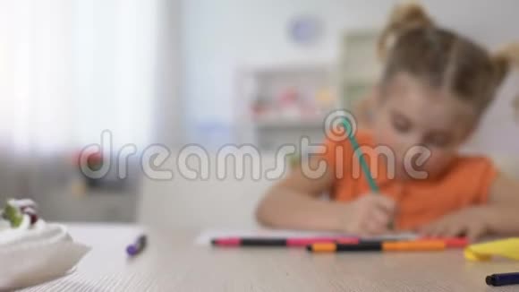 学习的小女孩用铅笔在家的桌子上写作童年教育视频的预览图