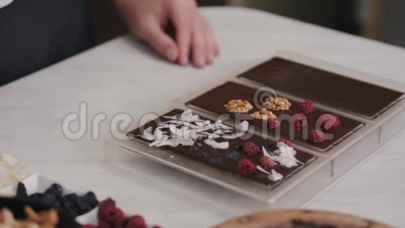 家庭主妇正在用浆果和核桃装饰巧克力视频的预览图