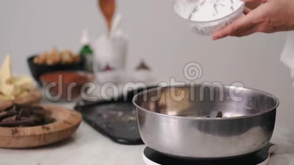 家庭主妇在碗里把面粉加到巧克力里视频的预览图