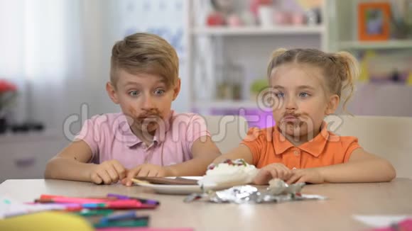 男性和女性孩子在餐桌上涂抹巧克力有害的食物疾病视频的预览图