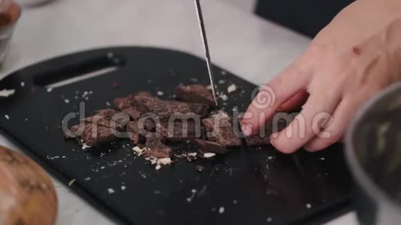女人把黑巧克力条分成几块视频的预览图