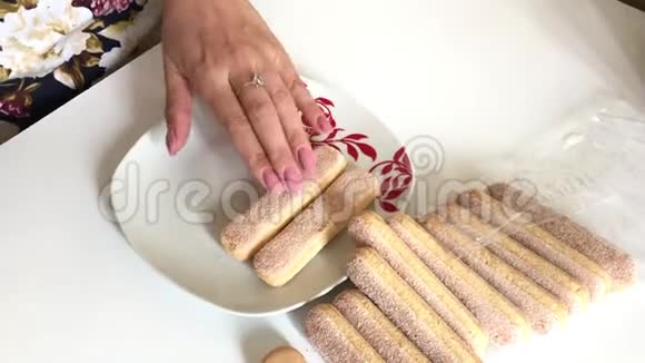 女人铺上奶油甜饼放在盘子里视频的预览图