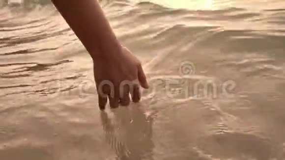特写女子手触水波的大海视频的预览图