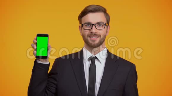 商务男士展示智能手机绿色屏幕和OK手势现金返还视频的预览图
